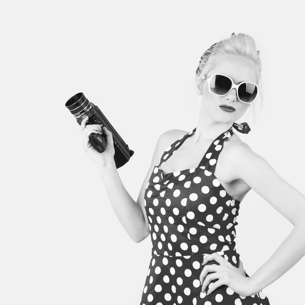 Pin-up tenant une caméra de l'Agence de communication 360° Polka Dot | Création de sites Web